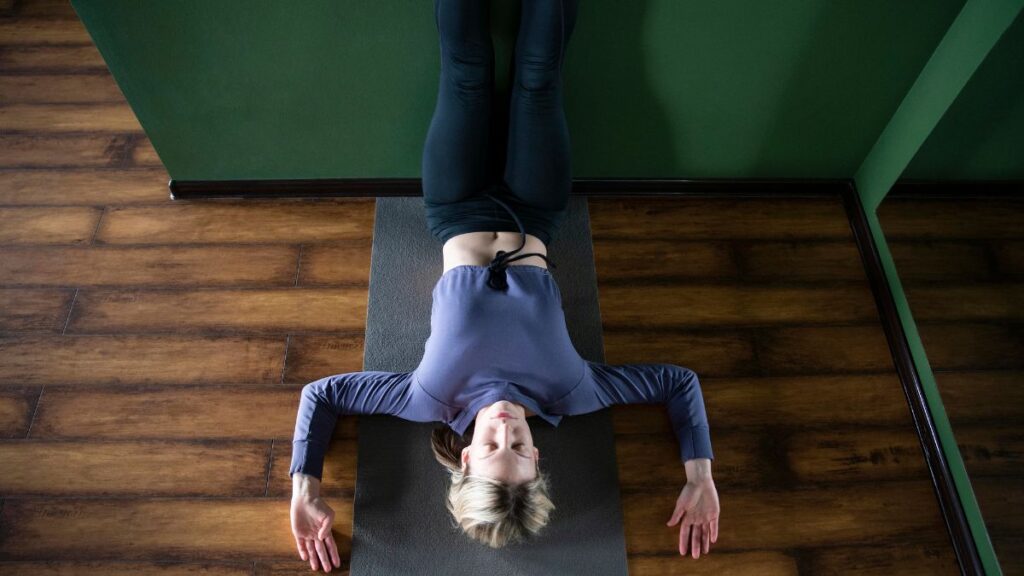 woman laying with legs up yoga