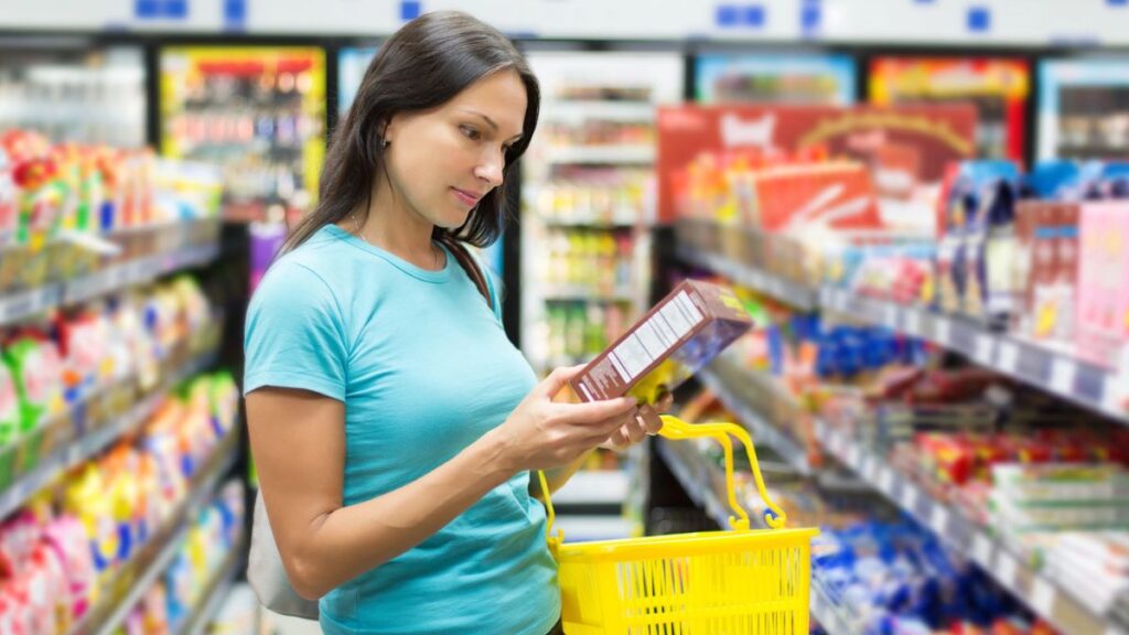 woman looking at box in grocery store