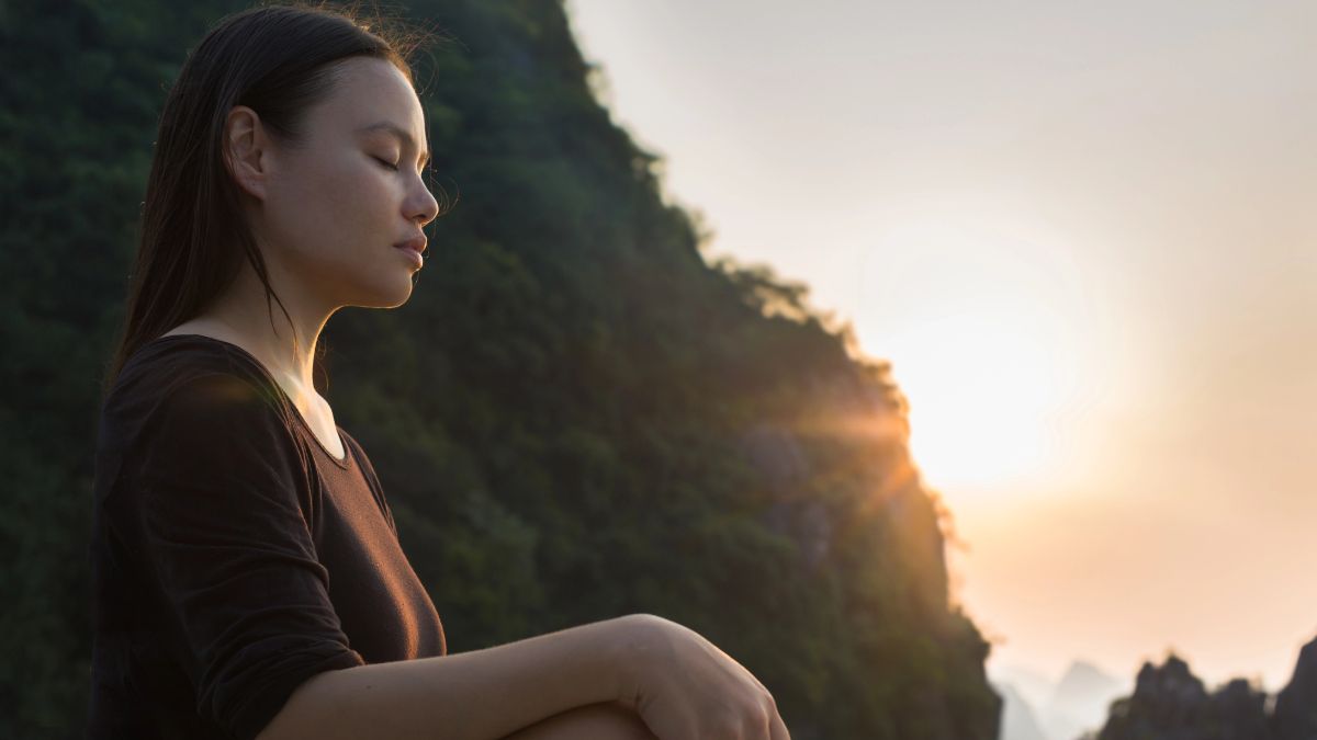 woman meditating at sundown