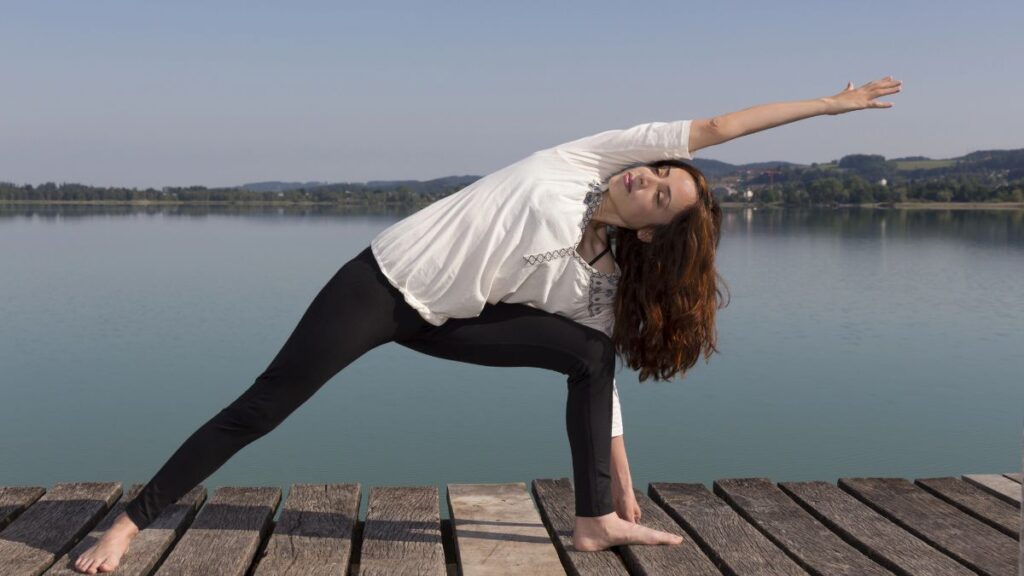 woman outside doing extended side angle pose yoga