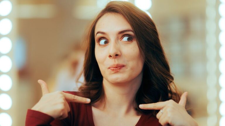 woman pointing to self smiling in mirror