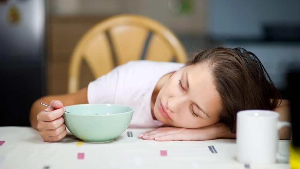 woman sleeping with coffee on table 