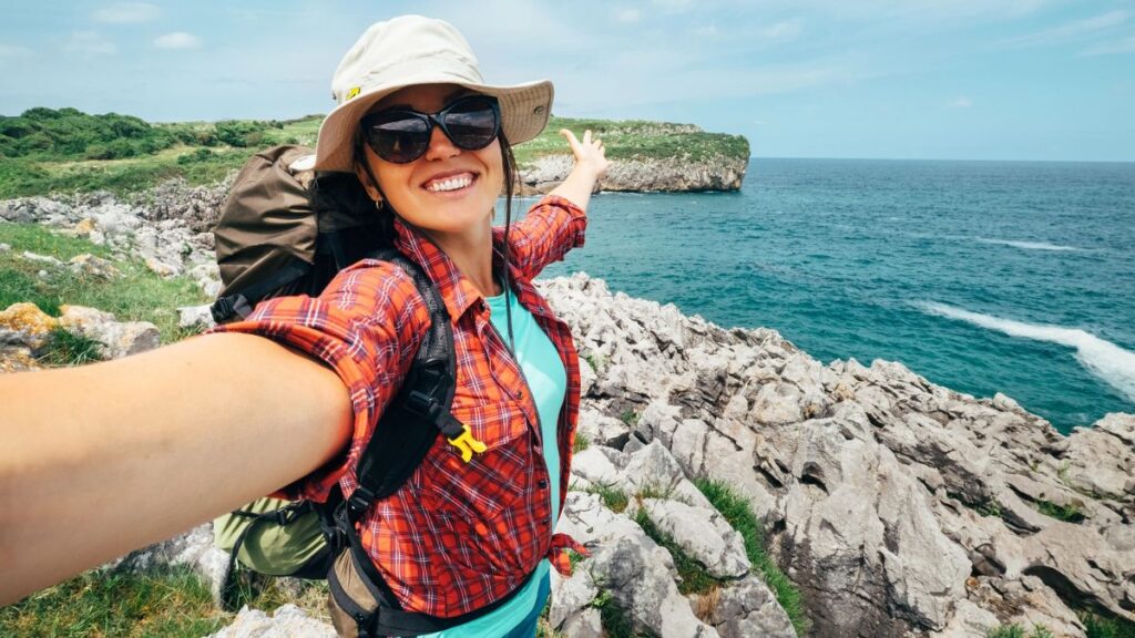 woman taking selfie traveling outside on cliff