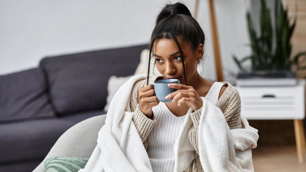 woman with coffee in blanket