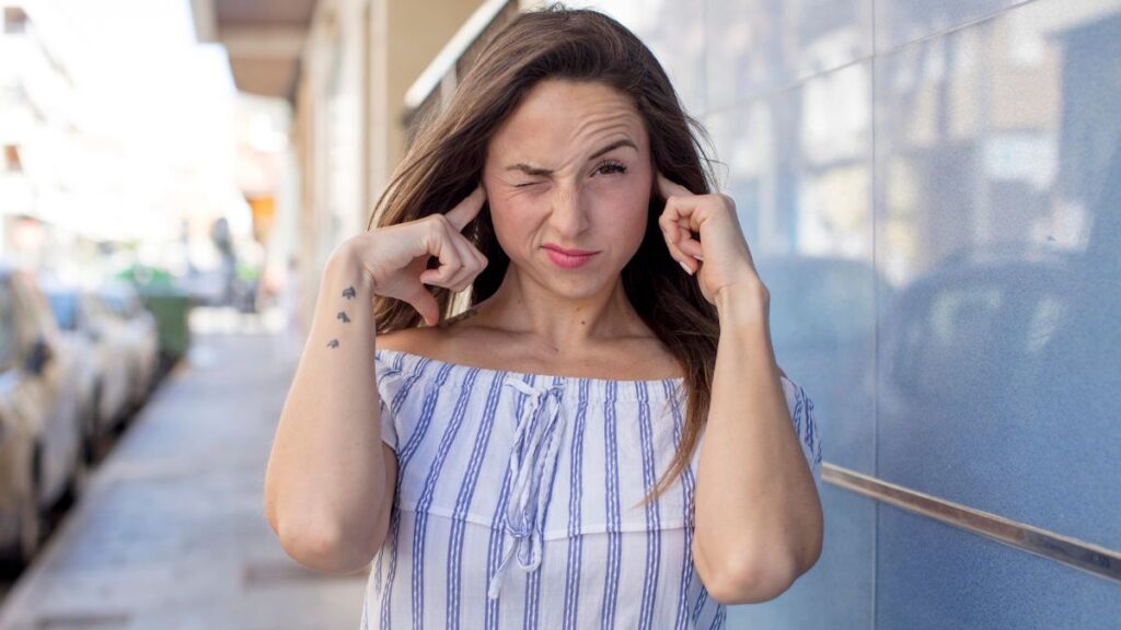 woman with fingers in ears 