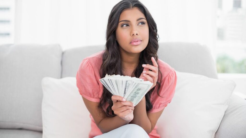 woman with money on couch