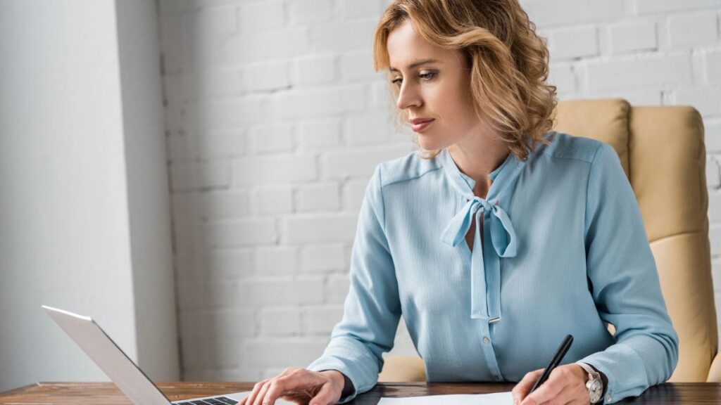 woman working at computer and writing