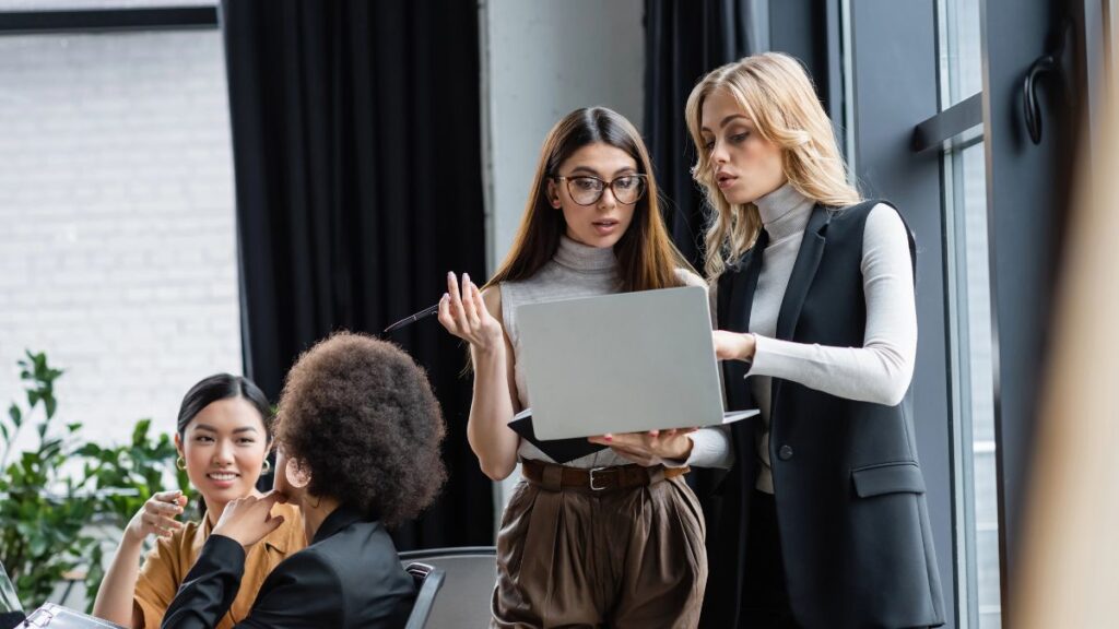 women talking at work on computer