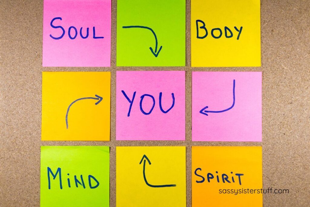 bulletin board with sticky notes that say soul, body, mind, spirit, you.