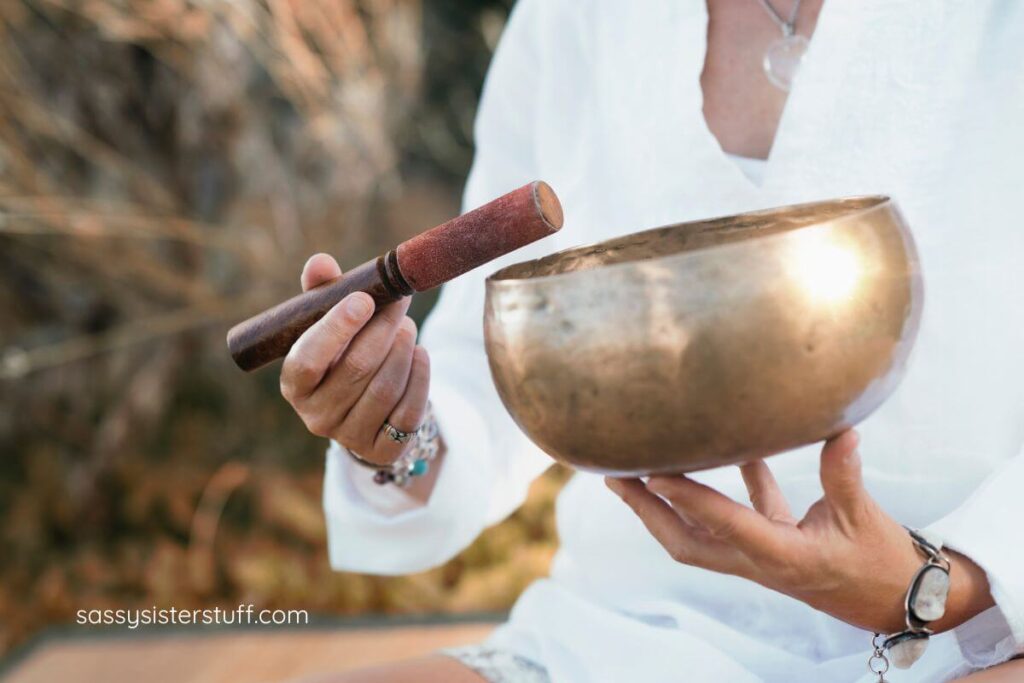 partial photo of a woman playing a sound bowl for relaxation.