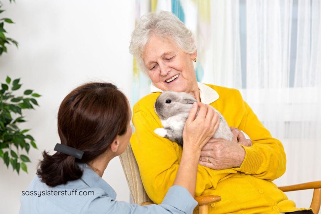 adult daughter sitting with her aging mother and a therapy rabbit.