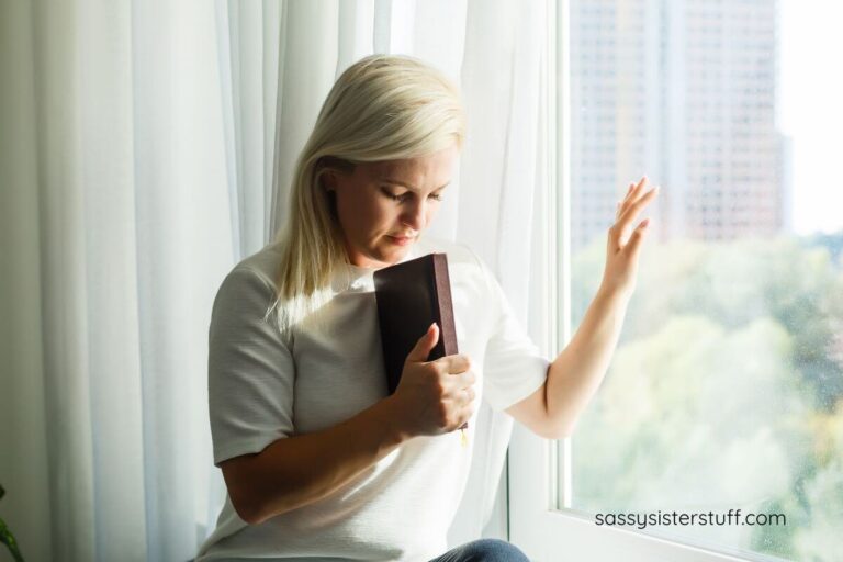 a woman sits on a windowsill and reflects on some faith everything will be alright quotes she read in the book she holds.