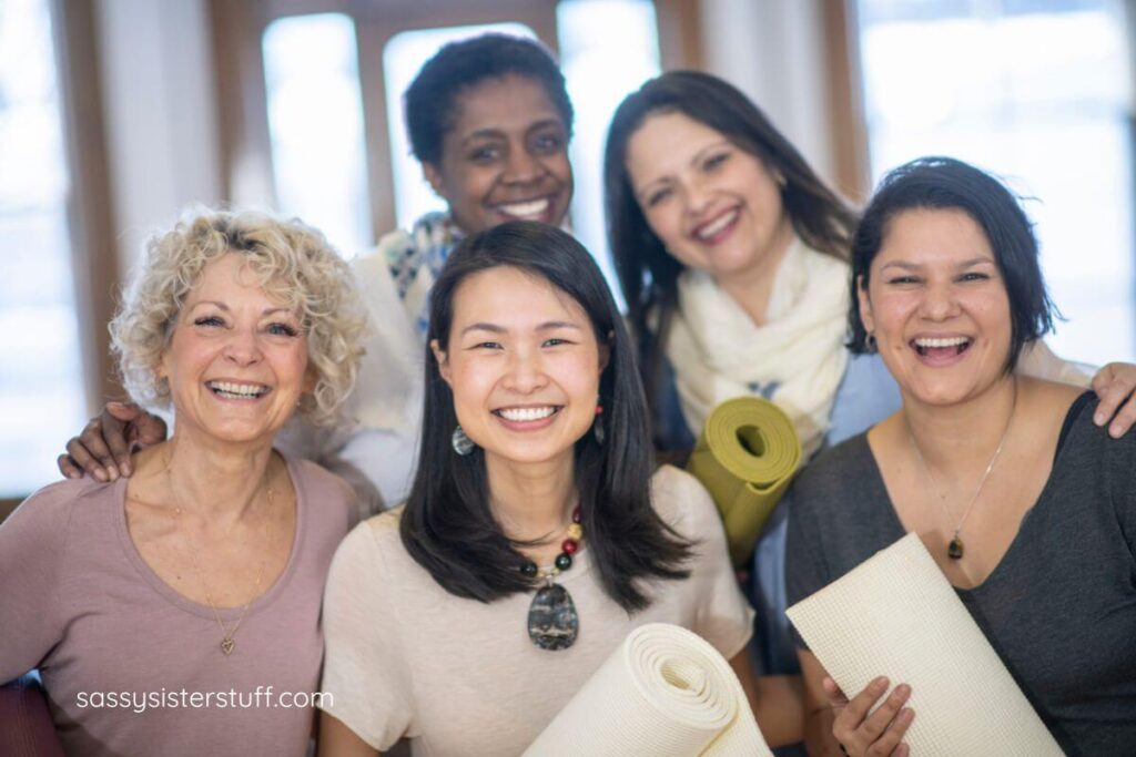 5 middle aged women pose together after yoga.