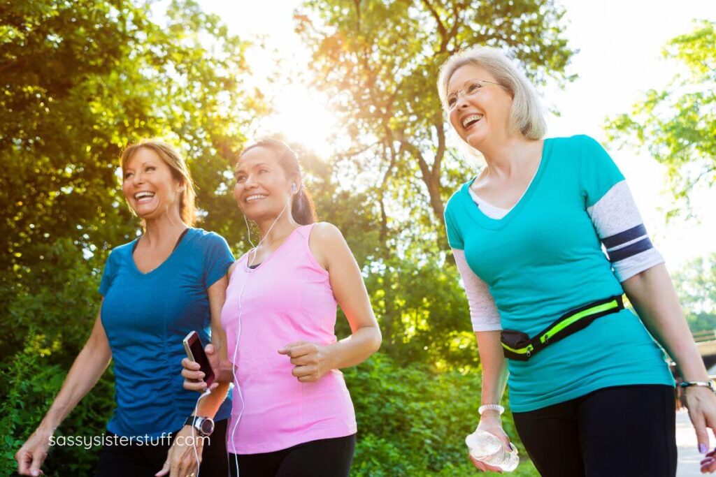 three middle aged women walk together to inspire each other.