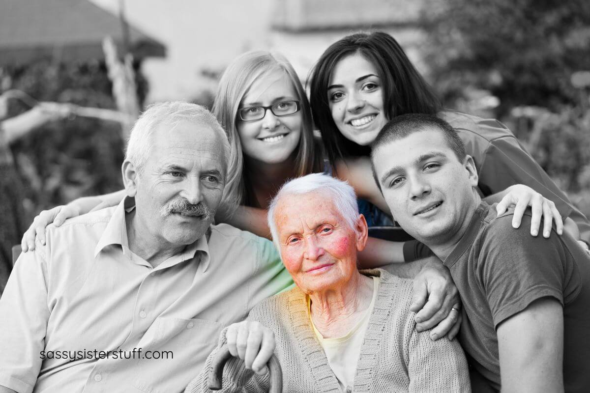 family of four surround an aging woman for a photo before doing some fun activities for seniors with dementia.