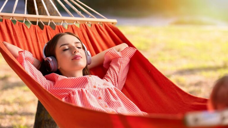 woman listening to music resting in hammock