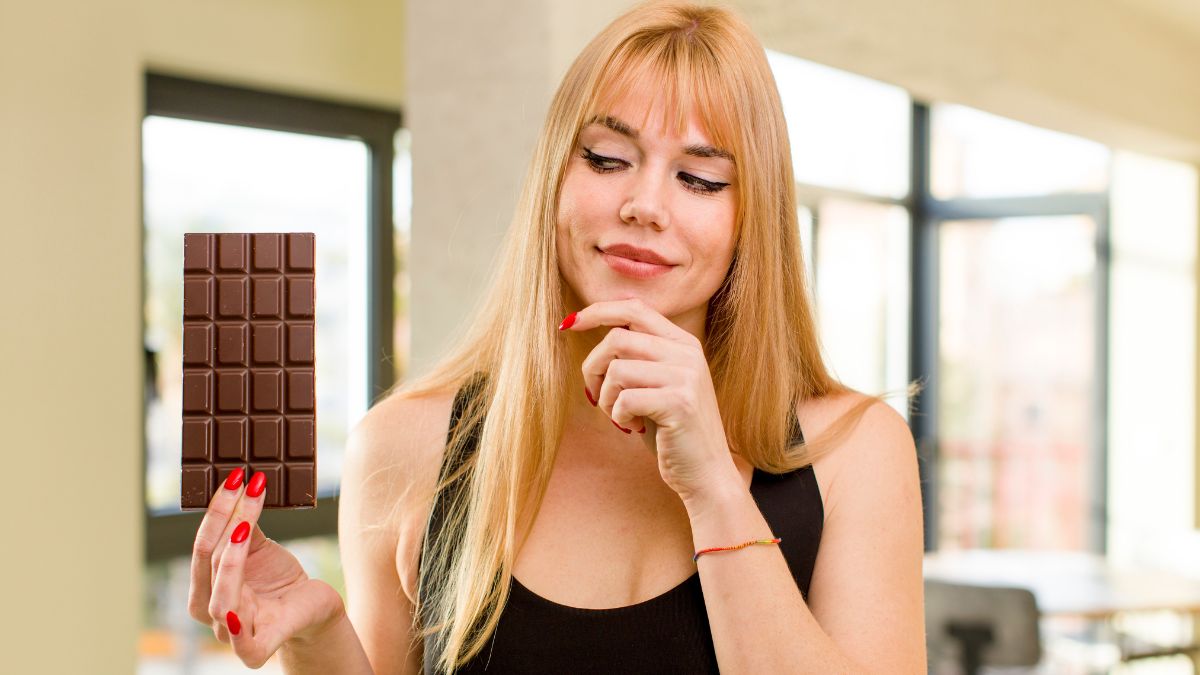 woman looking at chocolate and thinking