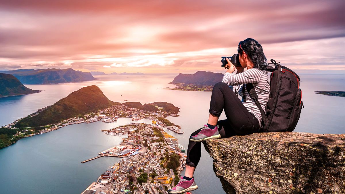 woman taking picture on cliff