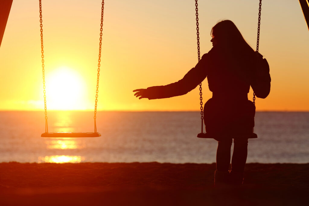 woman watching sunset on swing