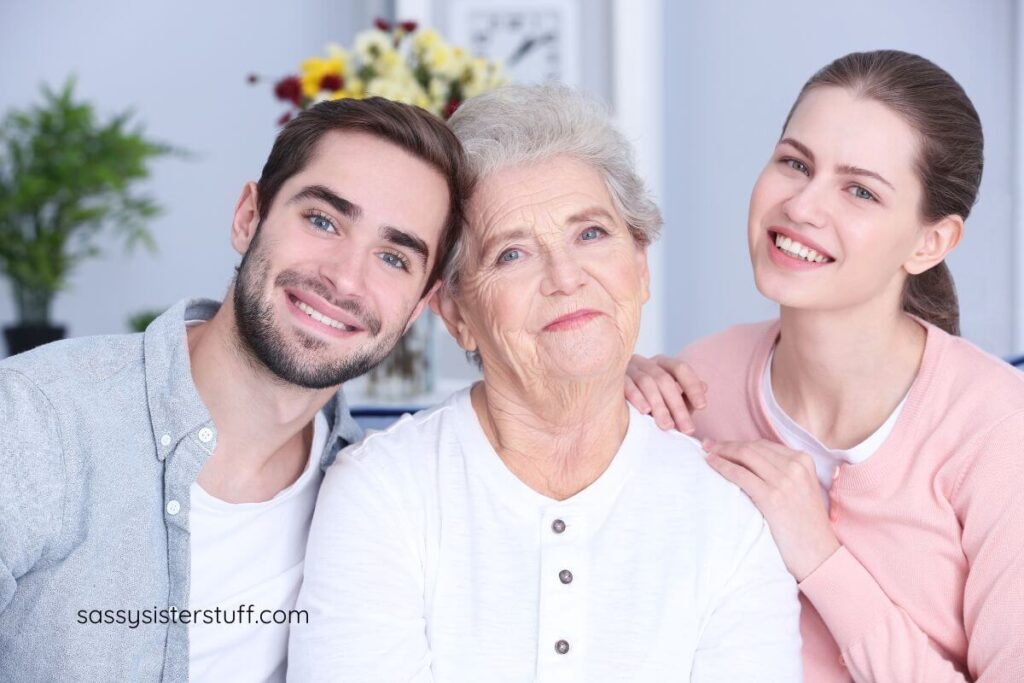 a grandmother and two adult grandchildren pose for a photo together.