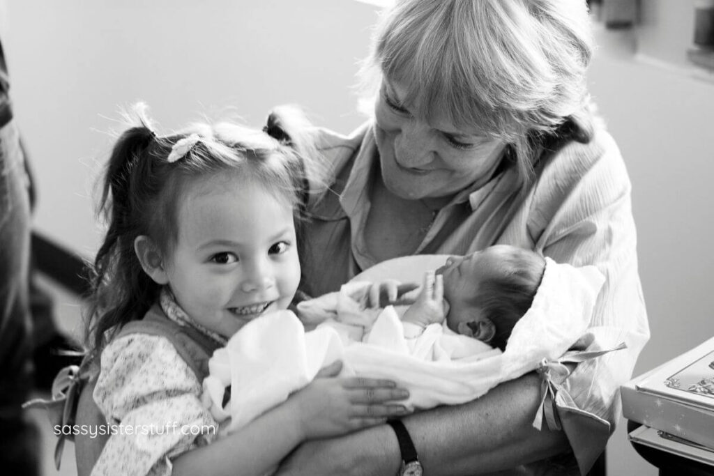 a grandmother and a young granddaughter meet a new baby sibling for the first time.