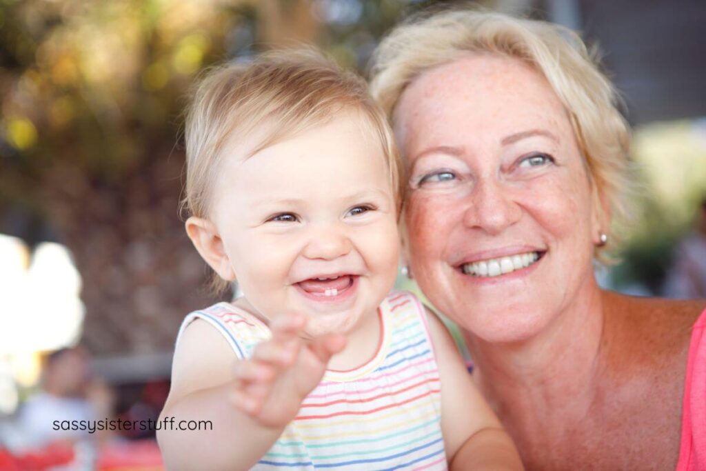 grandma and baby granddaughter check to check laughing at something.