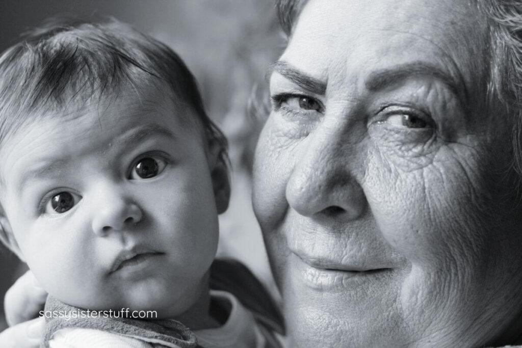 close up of grandmother and baby grandson cheek to cheek.