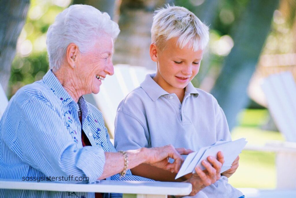 happy grandmother and young grandson look through pictures together.