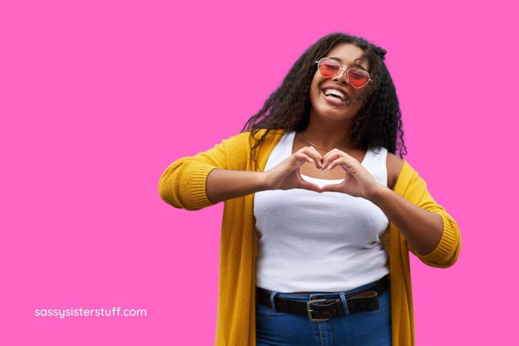 happy woman making a heart with her hands because she has been inspired by love yourself poems.