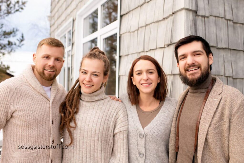 four young adults on a street corner smile for the camera.