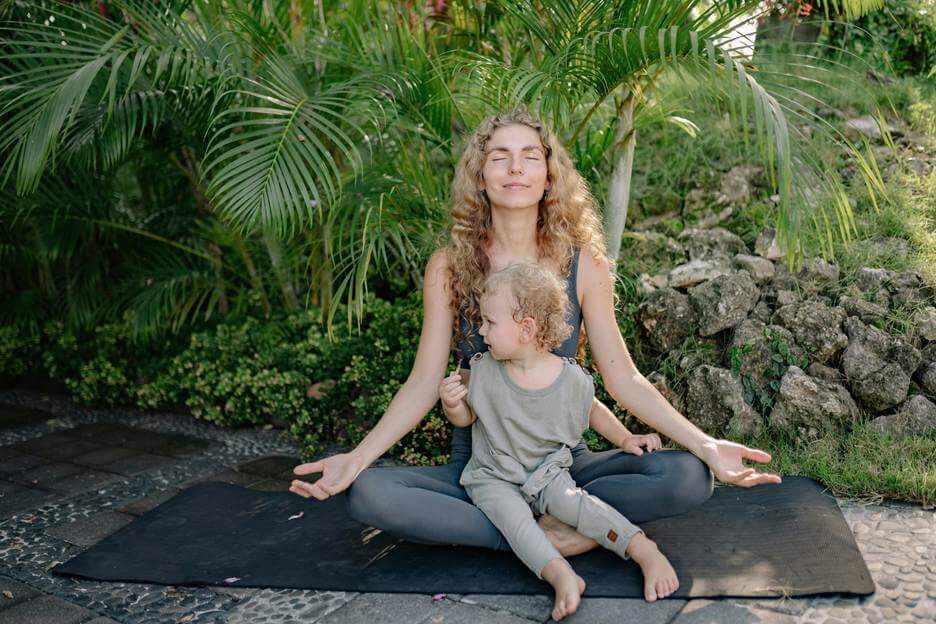 woman and child doing yoga outside.