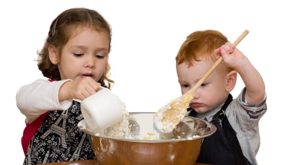 kids with large mixing bowl baking