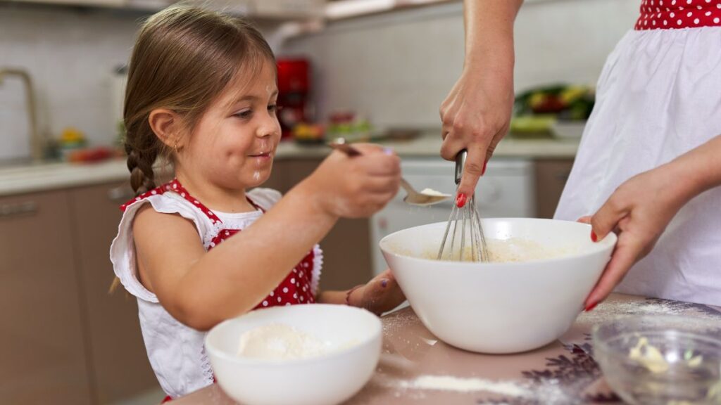 little girl baking with mom