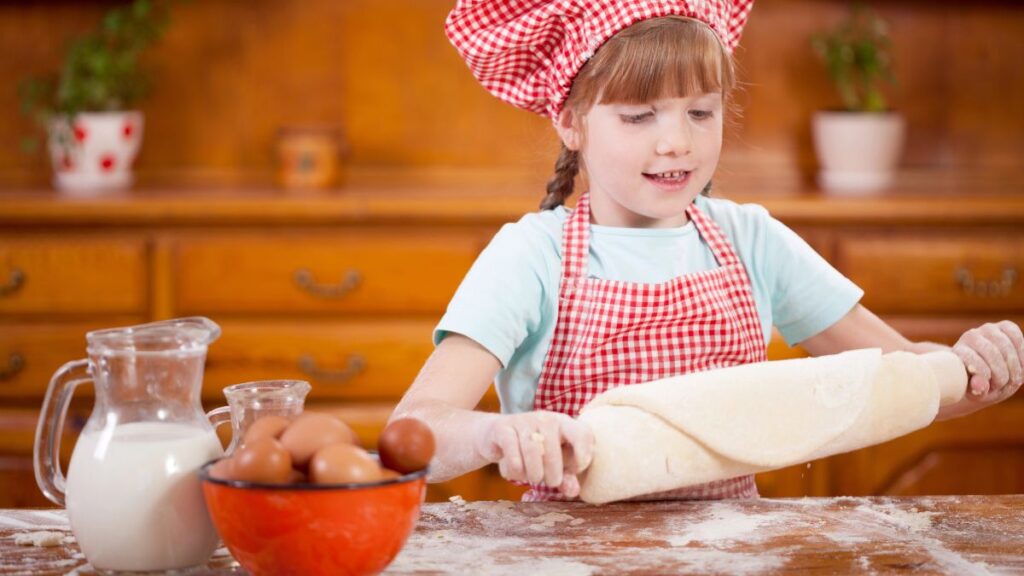 little girl rolling dough