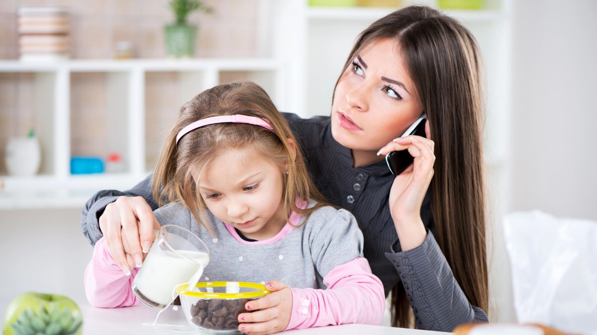 stressed mom on phone with daughter having breakfast