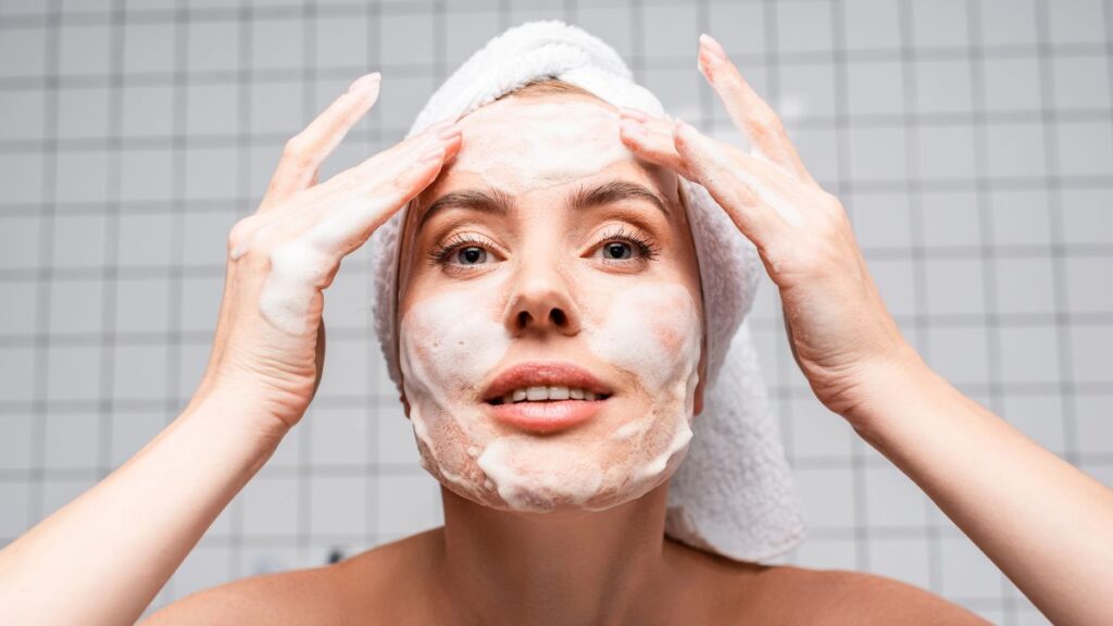 woman washing face in mirror