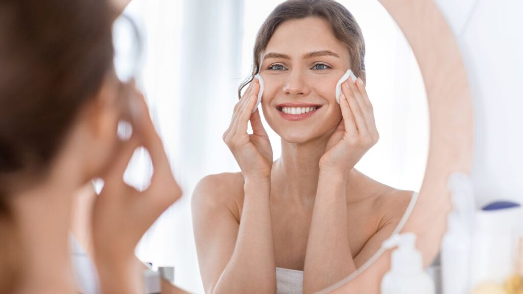 woman washing face in round mirror