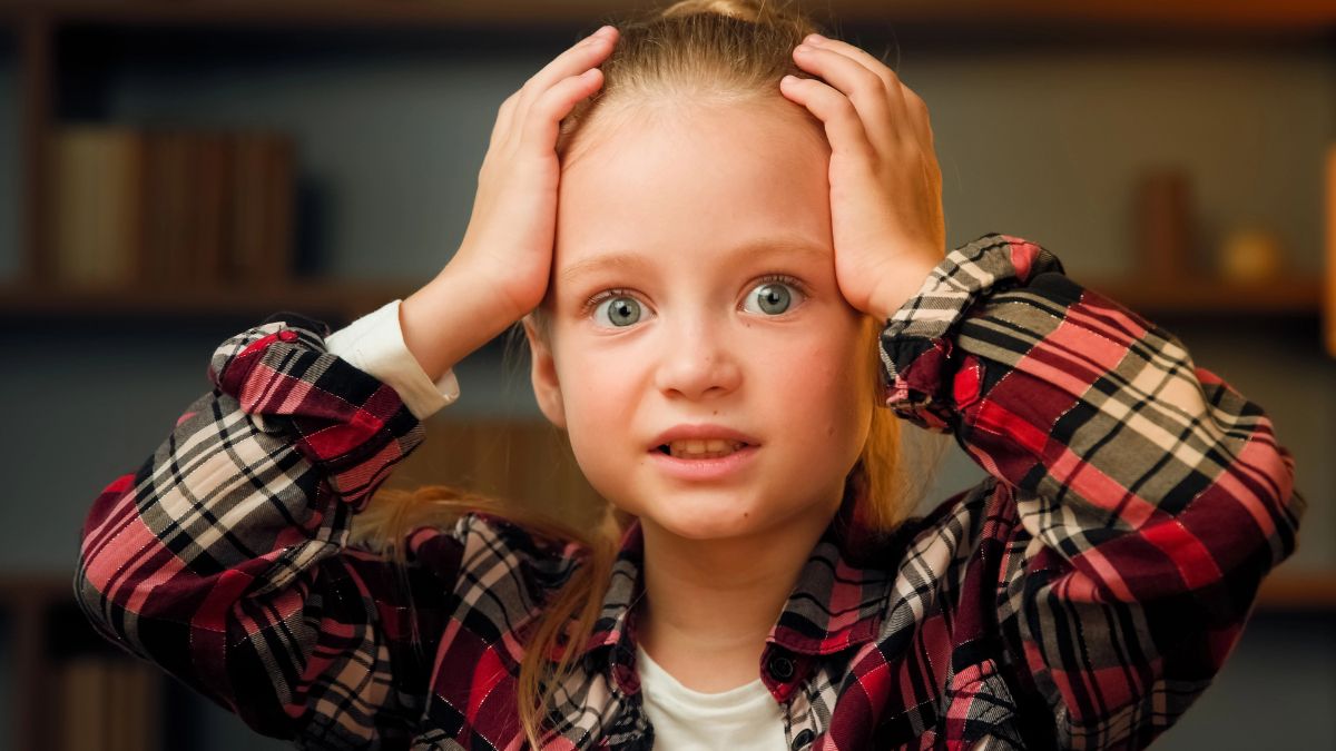 little girl looking confused with hands on head